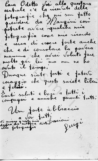 L’immagine riproduce la fotocopia della seconda facciata della lettera di Luigi Migliavacca ai suoi cari, scritta il giorno stesso della sua fucilazione. L’originale è scritto su un biglietto delle "Carceri giudiziarie di Torino", com’è scritto nella parte alta del foglio.